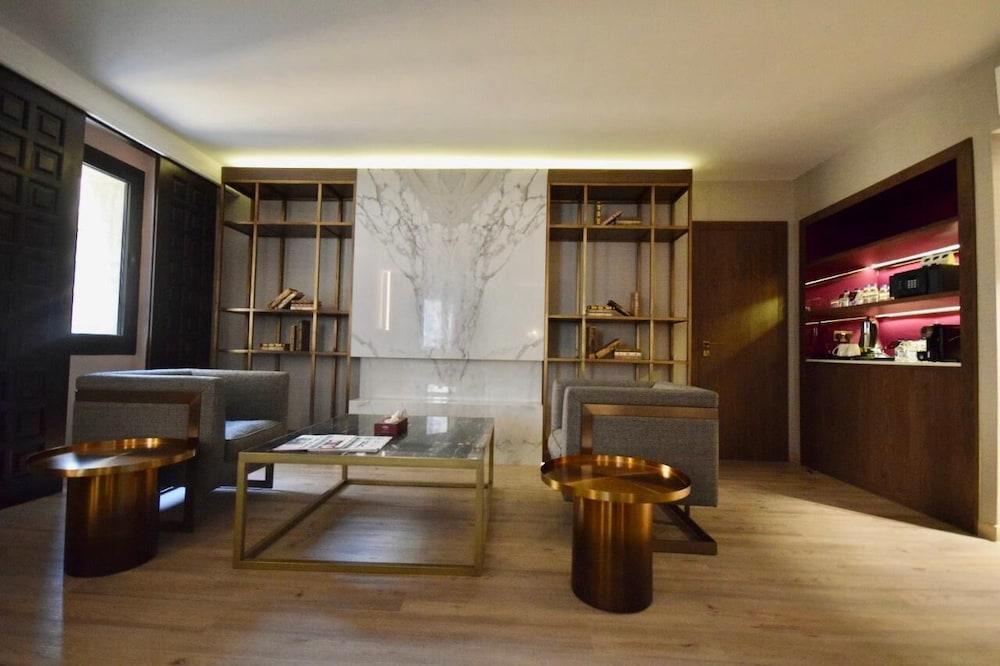 Makarem Ajyad Makkah Hotel Mekka Zewnętrze zdjęcie The photo shows a modern and stylish interior space, likely a living room or lounge area. On the left side, there are two comfortable gray armchairs positioned toward the center. A glass coffee table sits between them, featuring a few magazines or bo