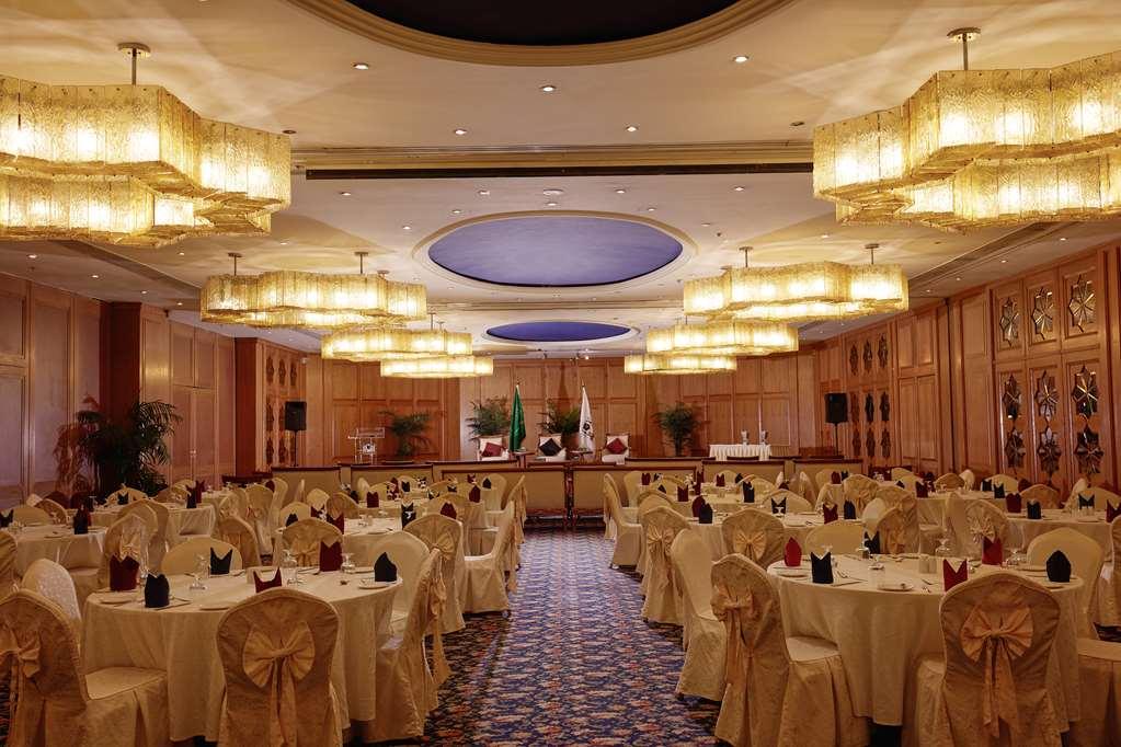 Makarem Ajyad Makkah Hotel Mekka Udogodnienia zdjęcie The photo shows an elegantly arranged banquet or conference room. There are several round tables covered with light-colored tablecloths and adorned with decorative napkins. The seating is also stylish, with chairs featuring matching coverings. The ro