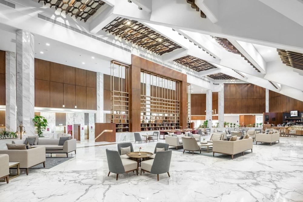 Makarem Ajyad Makkah Hotel Mekka Zewnętrze zdjęcie The photo shows a spacious and modern hotel lobby. It features a high ceiling with an elegant design, incorporating wooden accents and contemporary lighting. The floor is made of white marble, creating a bright and open atmosphere. 

In the foregroun