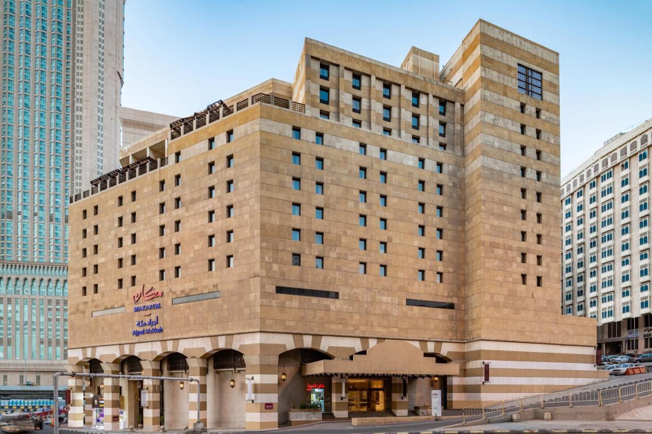 Makarem Ajyad Makkah Hotel Mekka Zewnętrze zdjęcie The photo shows a multi-story building with a distinctive architectural style. The facade features a combination of textured stone and concrete, giving it a contemporary yet somewhat traditional appearance. The building has multiple windows arranged 